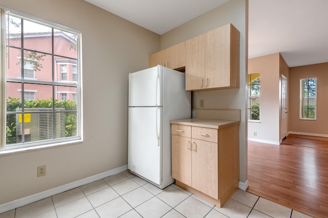 kitchen featuring white refrigerator, light wood-type flooring, and a wealth of natural light