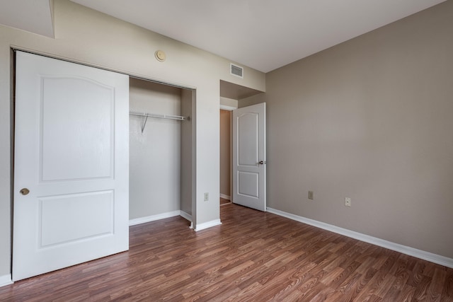 unfurnished bedroom with a closet and dark hardwood / wood-style floors