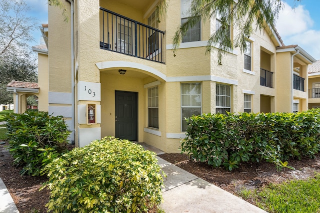 view of exterior entry featuring a balcony