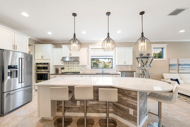 kitchen with white cabinetry, hanging light fixtures, and appliances with stainless steel finishes