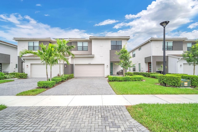 view of property with a front lawn and a garage