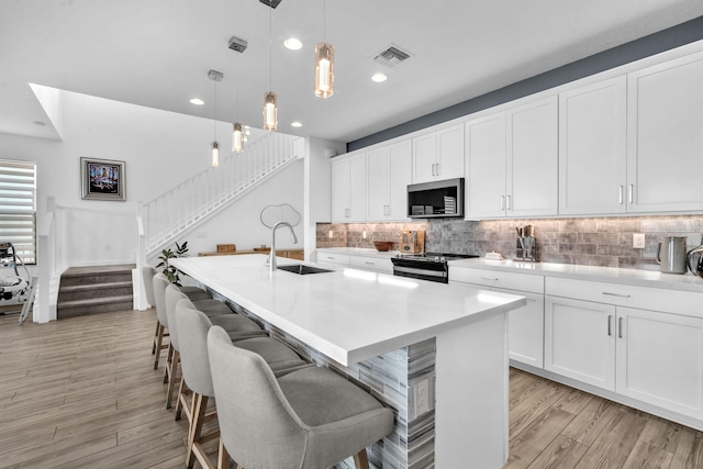 kitchen with pendant lighting, stainless steel microwave, light countertops, and range with electric stovetop