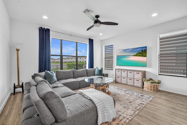 living area with baseboards, light wood-style flooring, visible vents, and recessed lighting