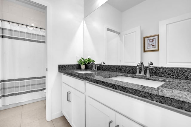 full bath with double vanity, a sink, toilet, and tile patterned floors