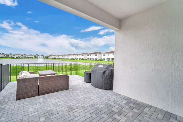 view of patio with a water view, a residential view, outdoor lounge area, and area for grilling