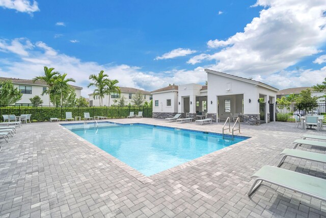 community pool featuring a patio area and fence