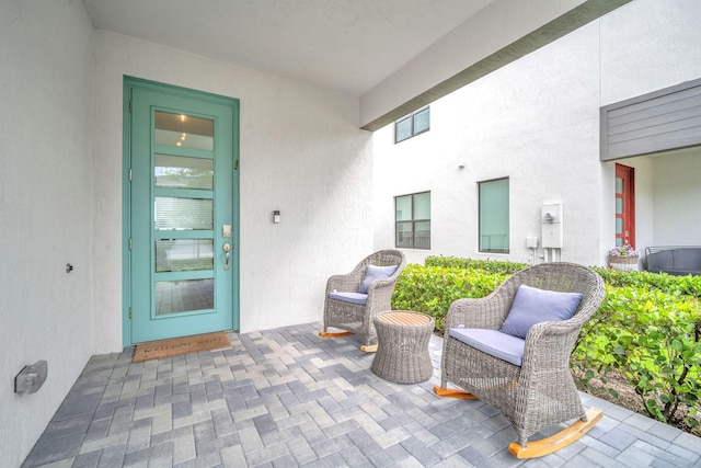 view of exterior entry with a patio and stucco siding