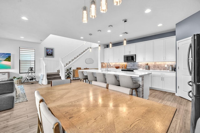 dining space featuring stairway, recessed lighting, visible vents, and light wood-style floors