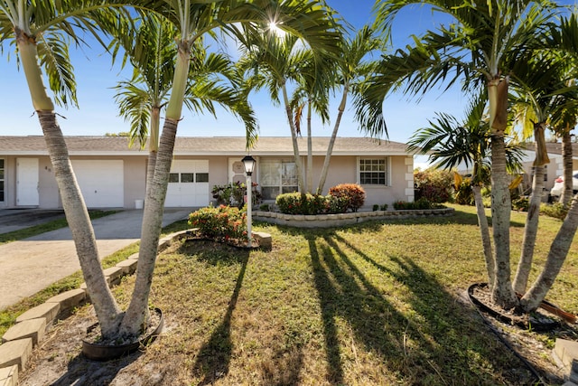 ranch-style house featuring a garage and a front lawn