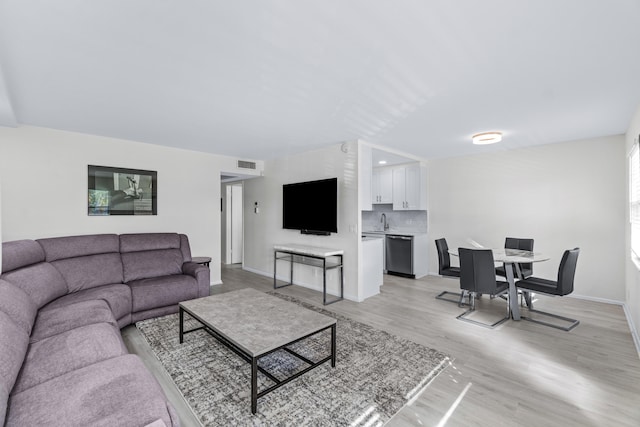 living room featuring light wood-type flooring and sink