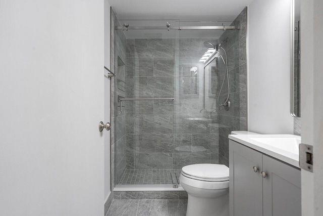 bathroom featuring toilet, vanity, and walk in shower