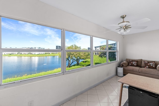 sunroom featuring a water view and ceiling fan