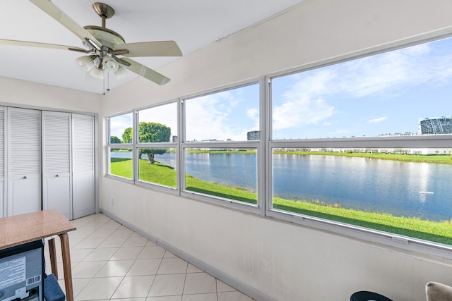 unfurnished sunroom with a water view and ceiling fan