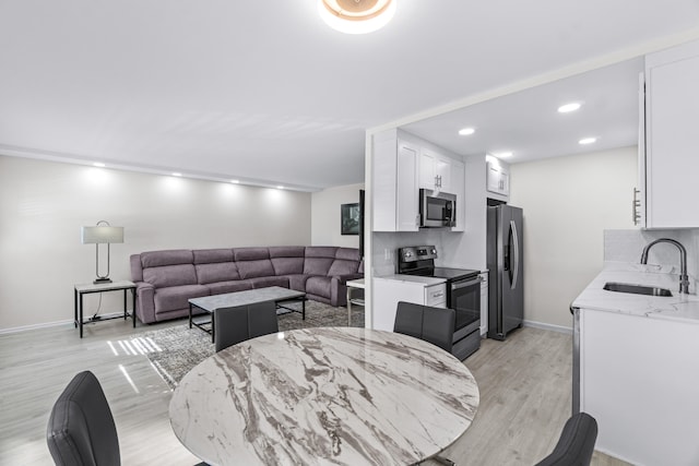 dining space featuring sink and light hardwood / wood-style floors