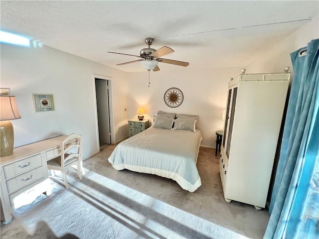 carpeted bedroom featuring a textured ceiling and ceiling fan