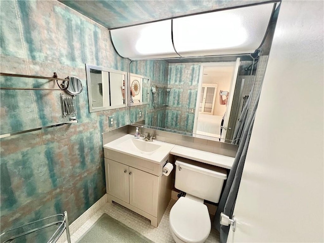 bathroom featuring vanity, toilet, and tile patterned flooring