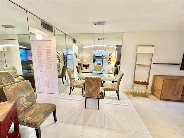 tiled dining room with a textured ceiling