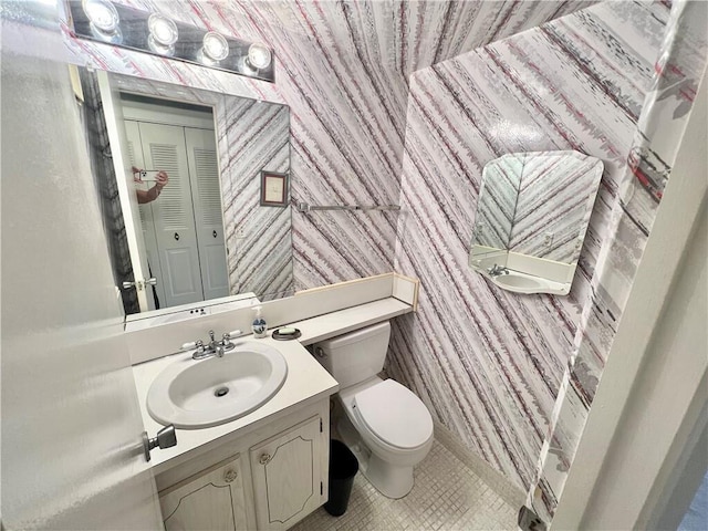 bathroom featuring toilet, vanity, and tile patterned flooring