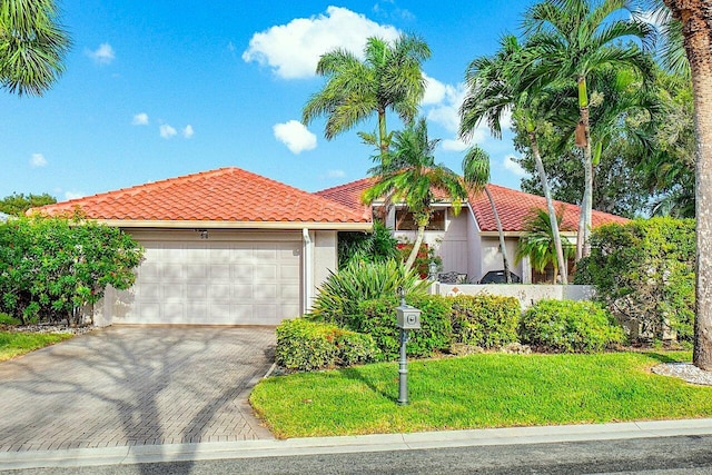 mediterranean / spanish house featuring a garage and a front yard