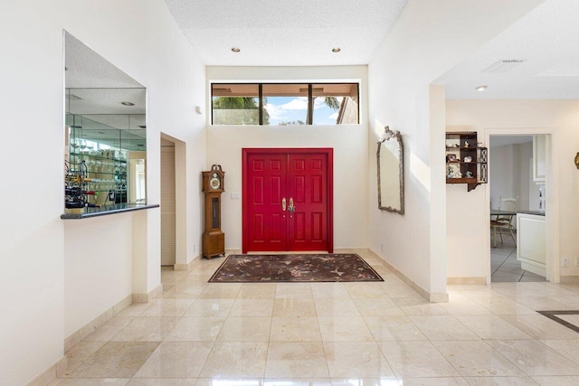 entryway with a high ceiling and a textured ceiling