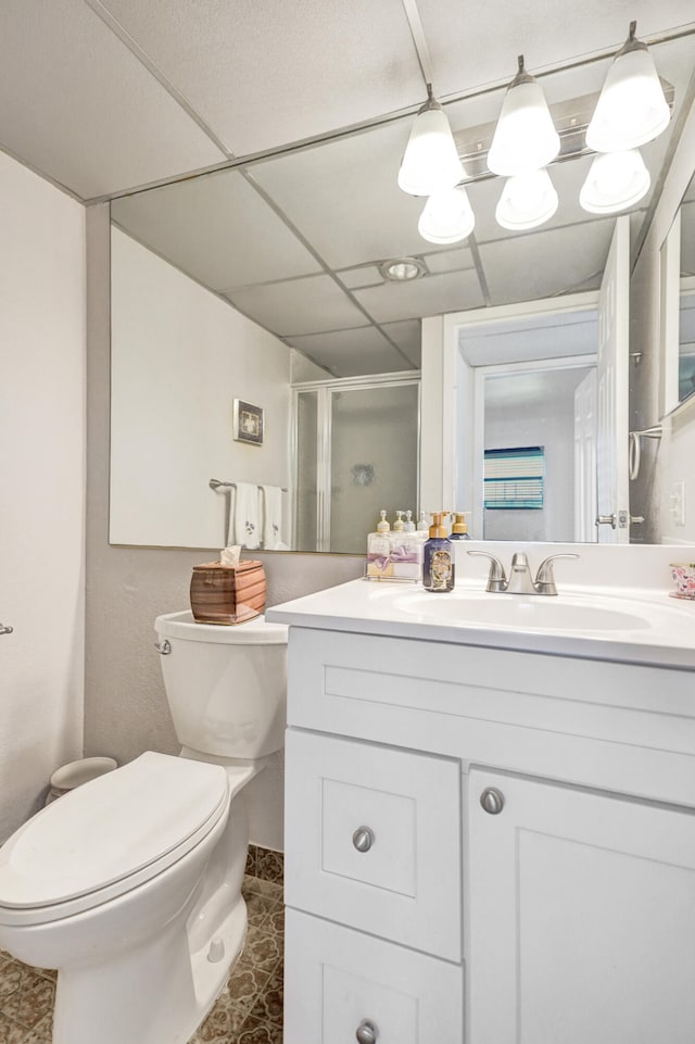 bathroom with tile patterned floors, toilet, vanity, a paneled ceiling, and an enclosed shower