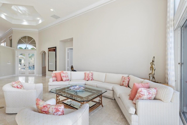 living room with crown molding, a towering ceiling, and french doors