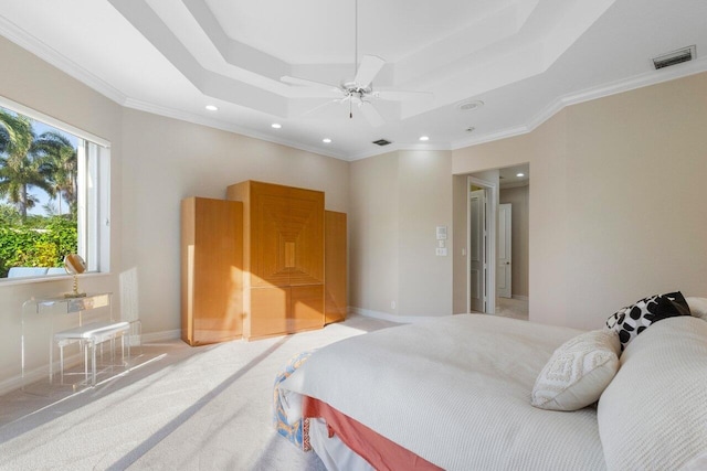 bedroom featuring ceiling fan, ornamental molding, a tray ceiling, and light carpet