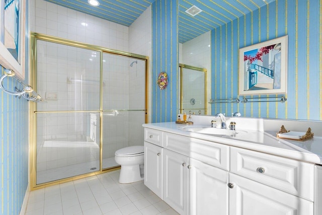 bathroom featuring vanity, tile patterned flooring, a shower with door, and toilet