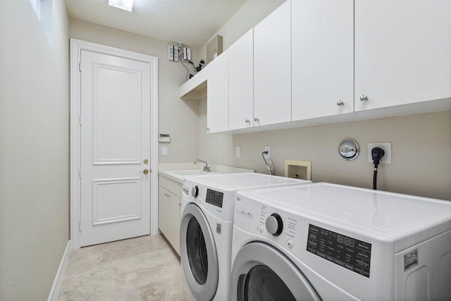 laundry room with sink, washing machine and dryer, cabinets, and a textured ceiling