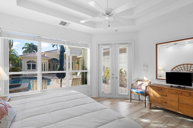 bedroom featuring a tray ceiling, access to outside, french doors, and ceiling fan