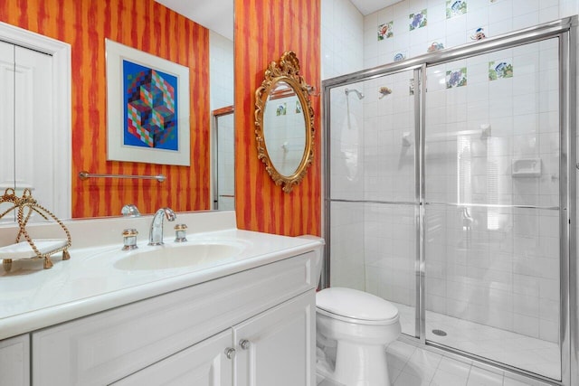 bathroom featuring vanity, toilet, tile patterned flooring, and a shower with door