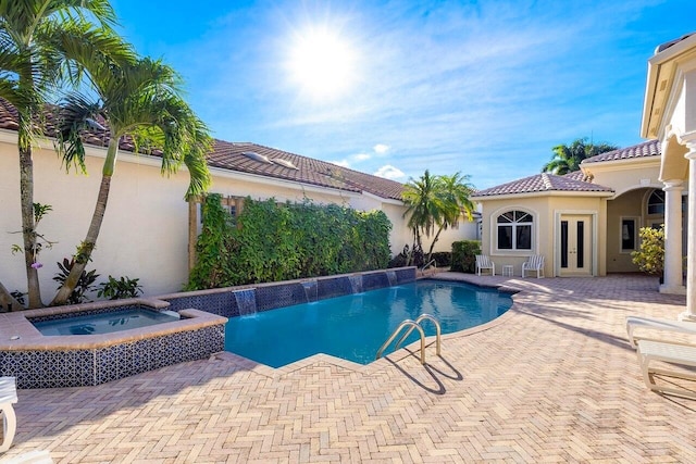 view of pool featuring a patio area, a pool with connected hot tub, and french doors