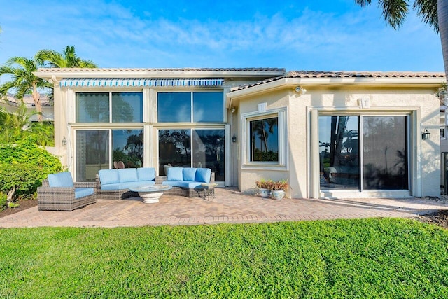 back of property featuring outdoor lounge area, a patio area, and a lawn