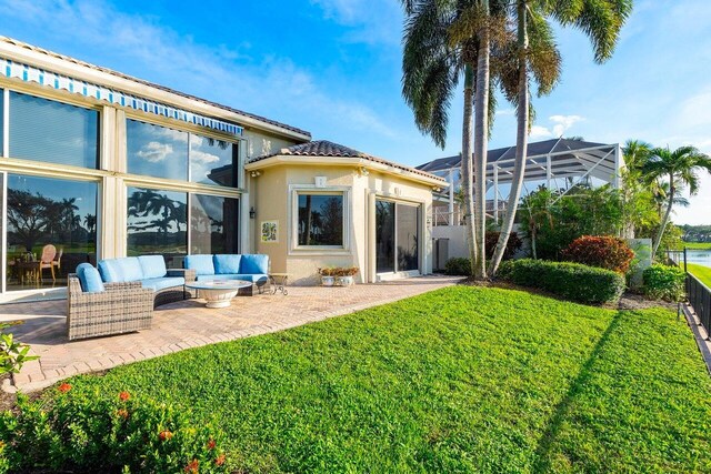 rear view of house featuring a yard, an outdoor hangout area, and a patio