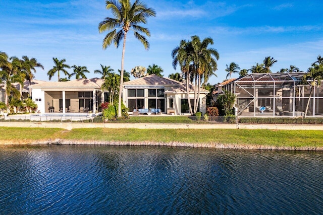 rear view of property with a water view and glass enclosure