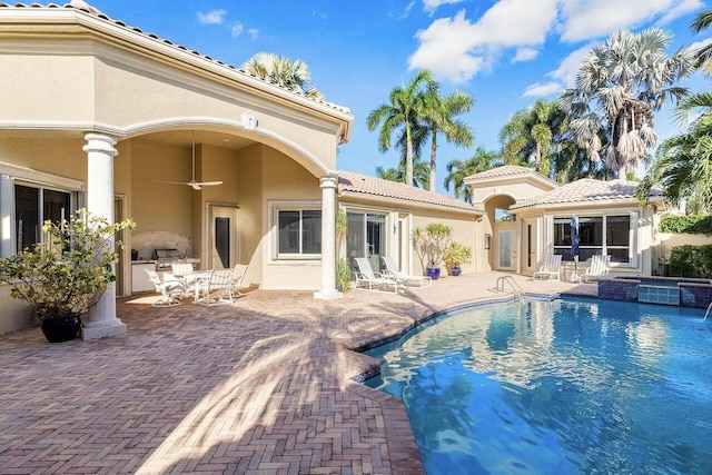 back of property featuring area for grilling, an outdoor pool, a patio, stucco siding, and ceiling fan