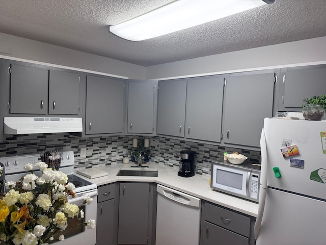 kitchen with white appliances, tasteful backsplash, and gray cabinetry