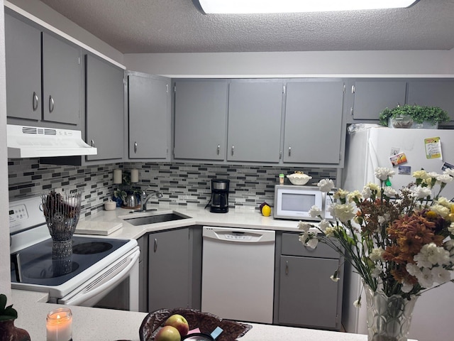 kitchen featuring white appliances, a textured ceiling, gray cabinetry, and sink