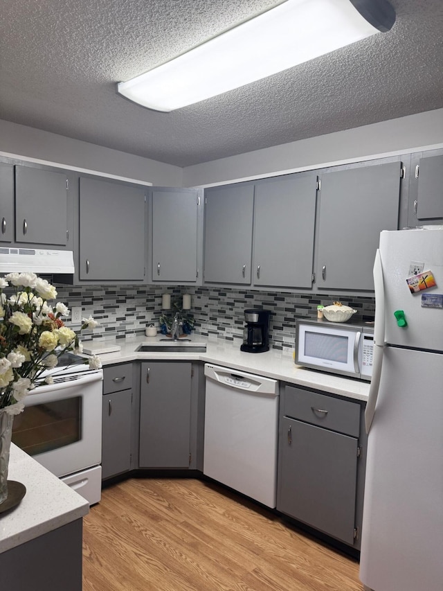 kitchen with white appliances, gray cabinets, and sink