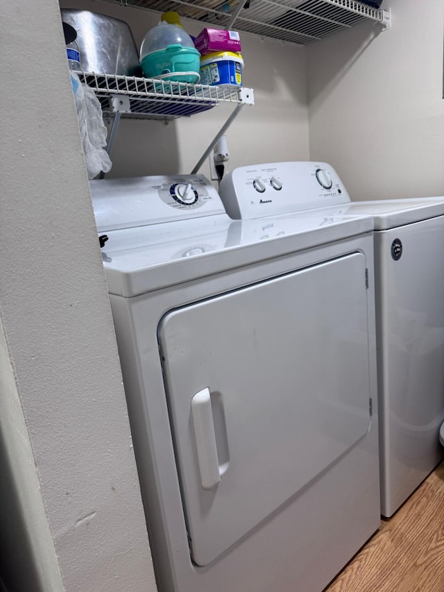 laundry area with light wood-type flooring and washing machine and dryer