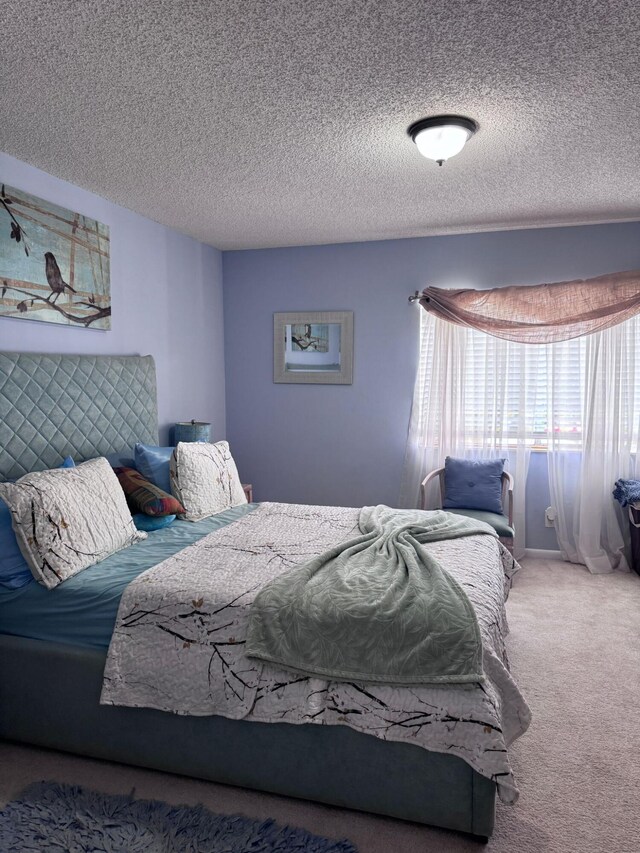 bedroom with a textured ceiling and carpet