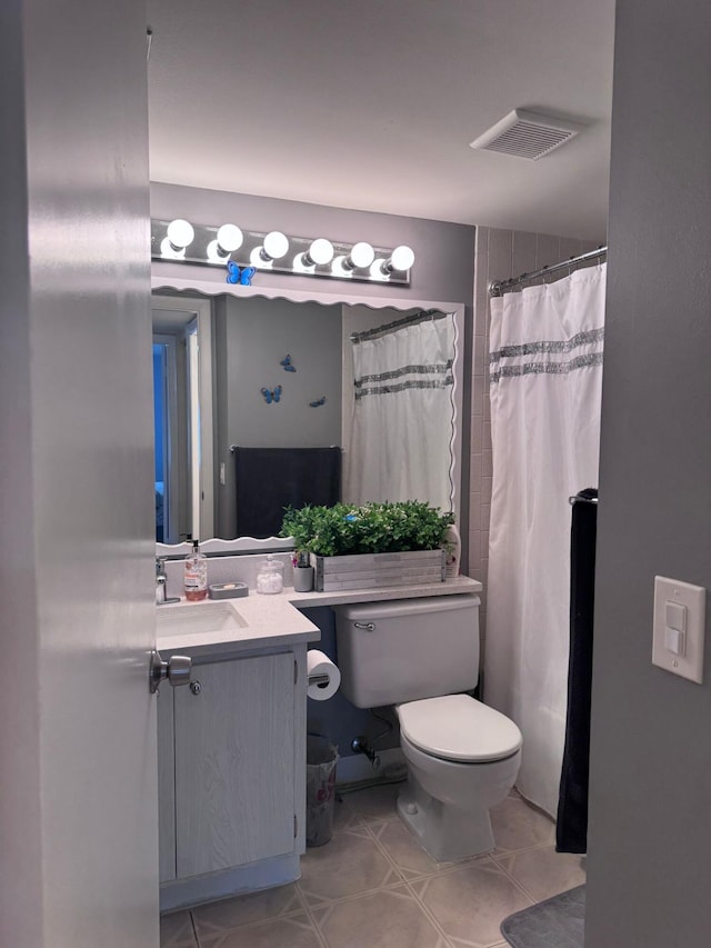 bathroom with toilet, vanity, and walk in shower