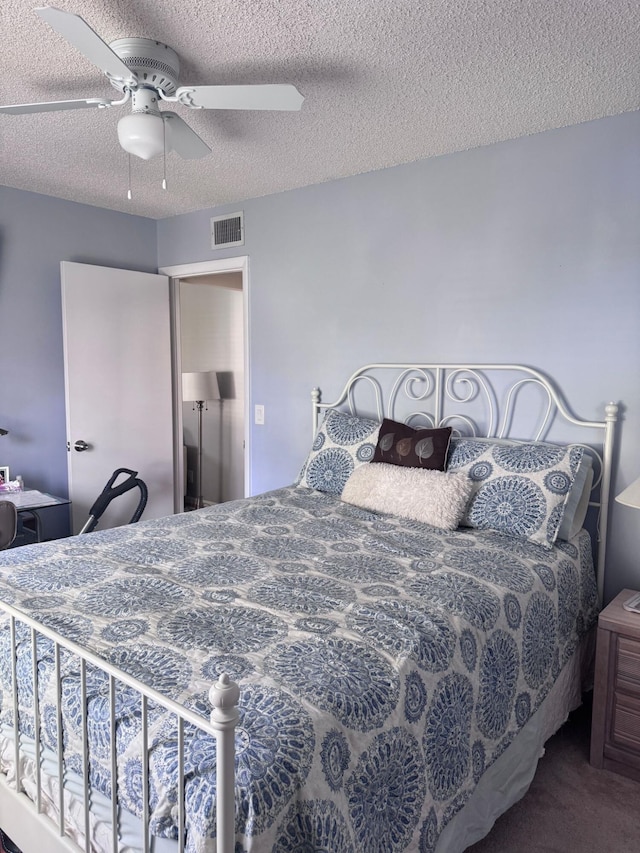 bedroom with ceiling fan, a textured ceiling, and carpet flooring