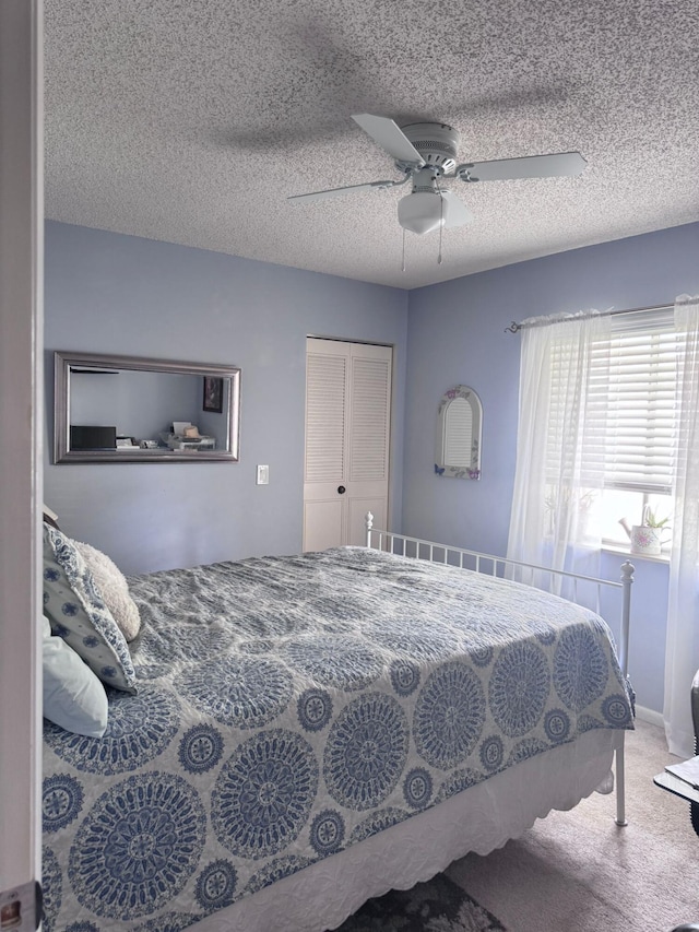 bedroom with carpet flooring, a textured ceiling, and ceiling fan