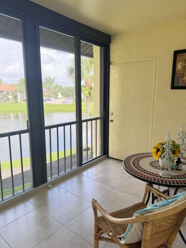 entryway featuring light tile patterned floors and a water view