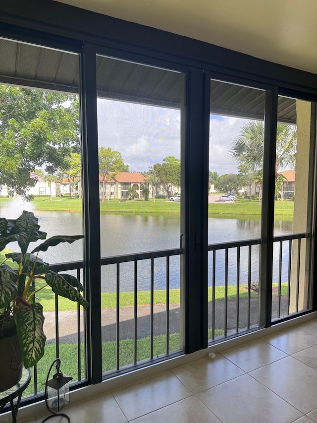 doorway to outside featuring tile patterned flooring, a water view, and a wealth of natural light