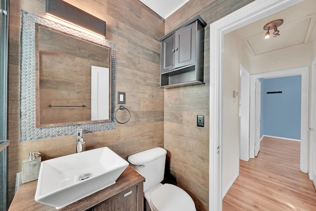 bathroom with tile walls, vanity, wood-type flooring, and toilet