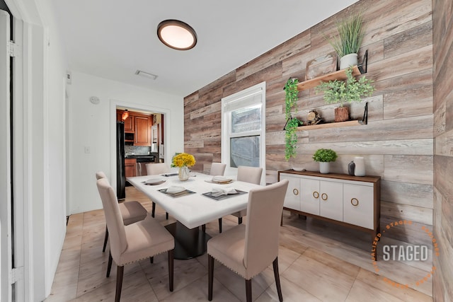 dining area featuring wooden walls