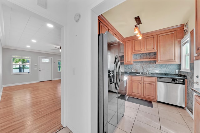 kitchen featuring decorative backsplash, ceiling fan, appliances with stainless steel finishes, light wood-type flooring, and ornamental molding