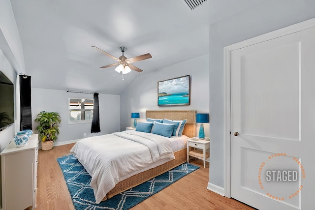 bedroom with ceiling fan, wood-type flooring, and lofted ceiling